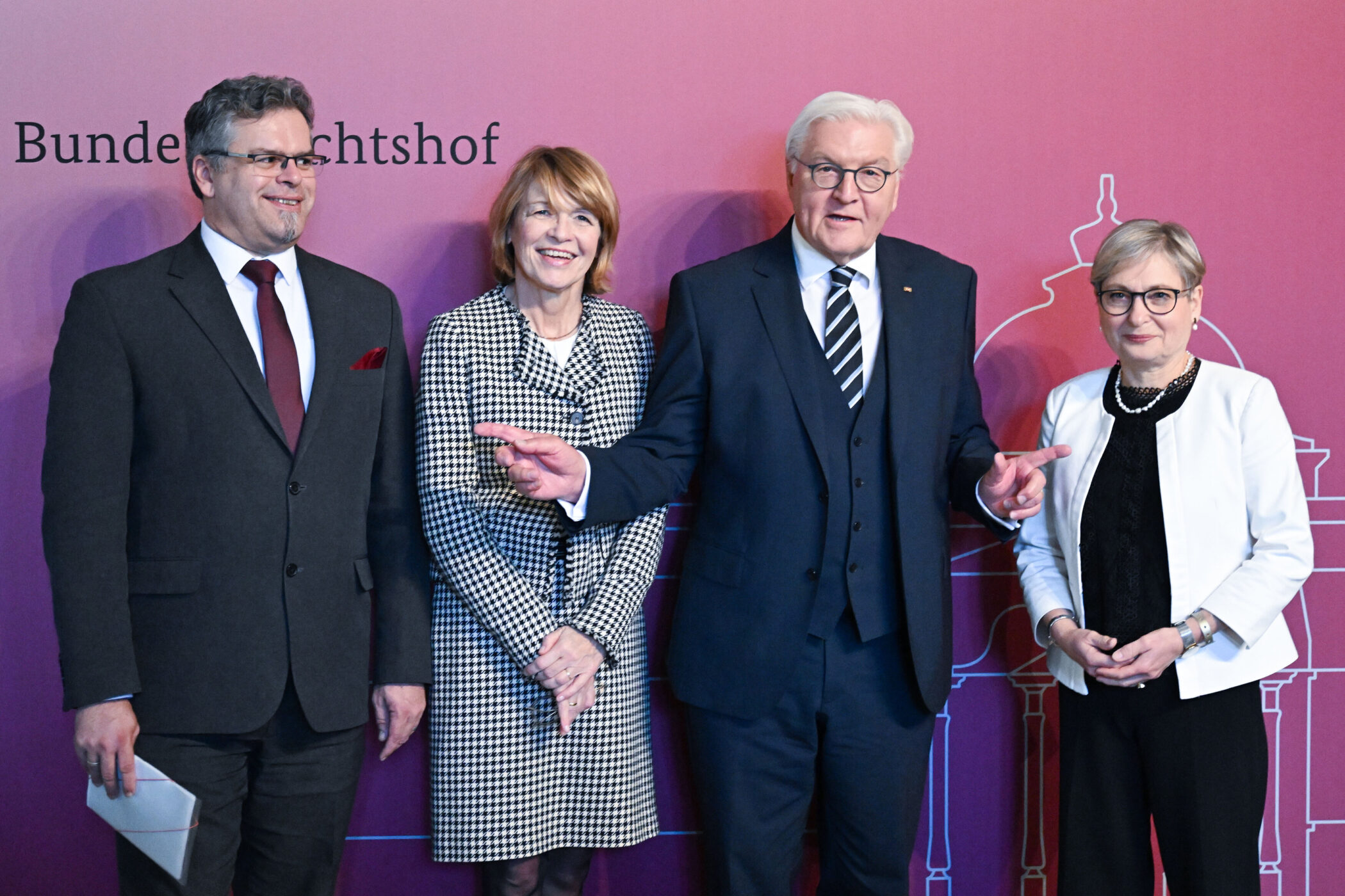 Vier Personen vor einer Wand mit der Aufschrift "Bundesgerichtshof".