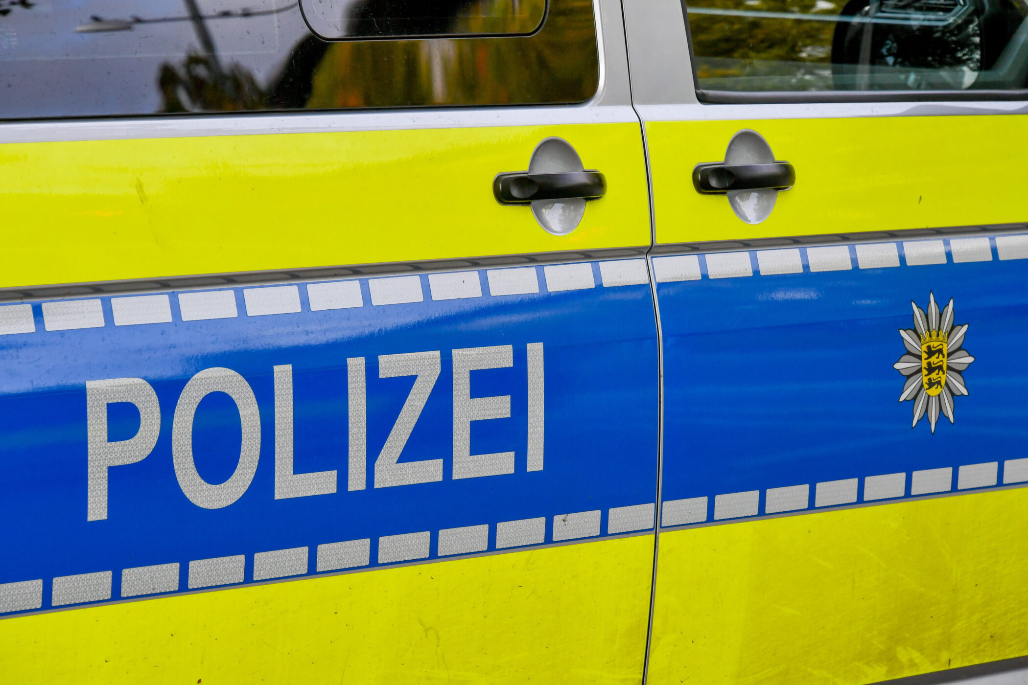 Seitenansicht eines Polizeiautos mit Schriftzug "POLIZEI".