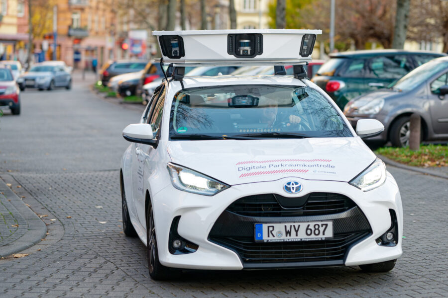 Weißes Auto mit Kameras auf dem Dach, Aufschrift "Digitale Parkraumkontrolle".