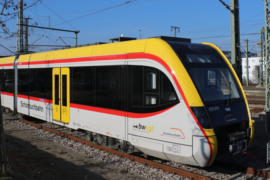 Zug der Schönbuchbahn mit gelber Front und rotem Streifen auf Gleisen.