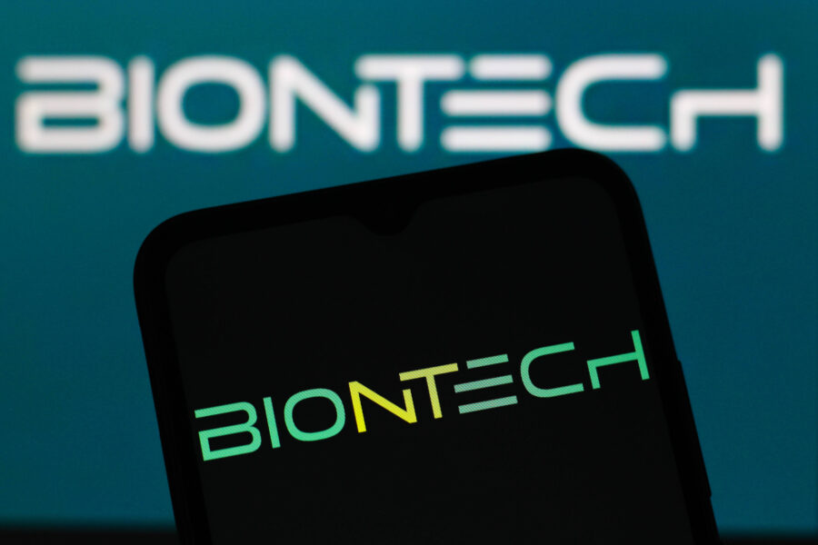Smartphone mit BioNTech-Logo, Hintergrund unscharf.
