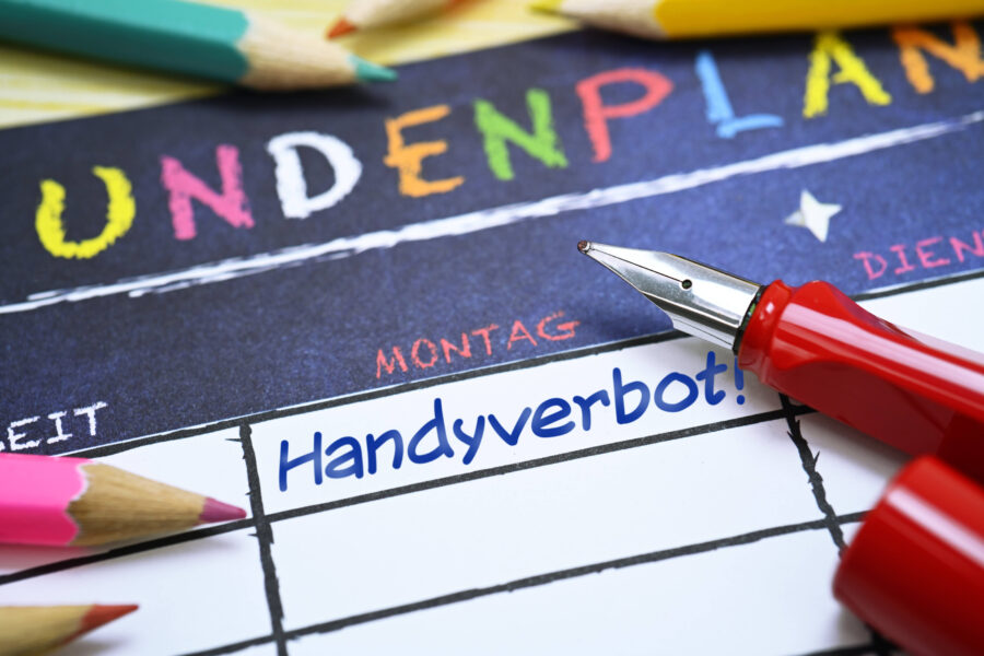 Stundenplan mit Stift und Buntstiften, Text: "Handyverbot!" am Montag.