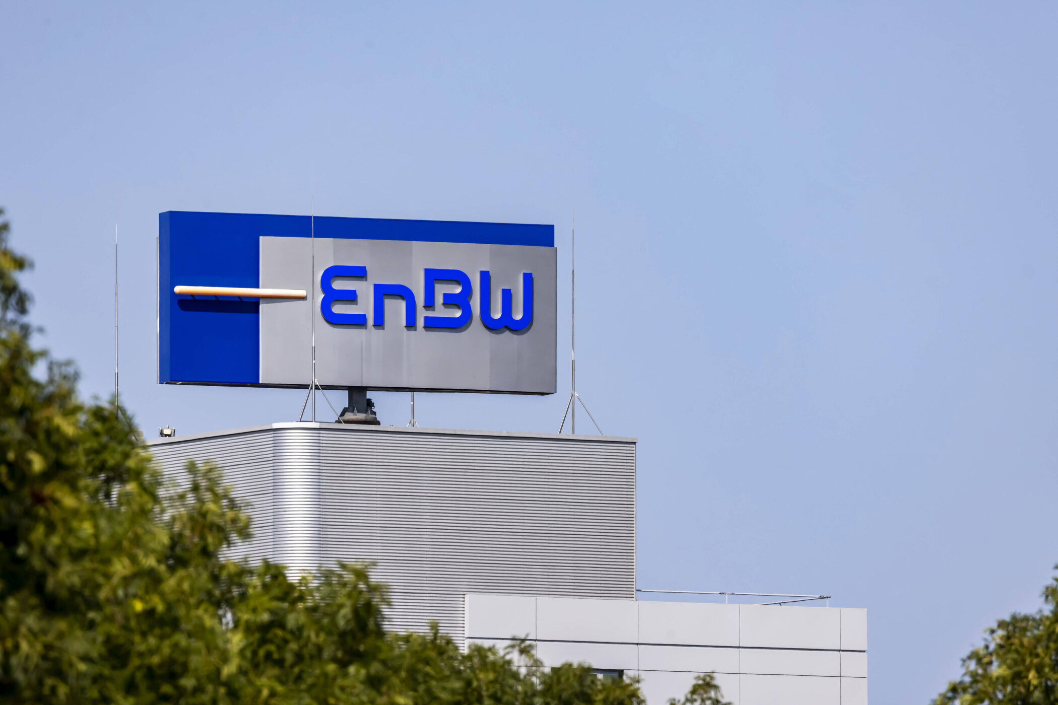 Gebäude mit EnBW-Logo auf dem Dach, blauer Himmel im Hintergrund.