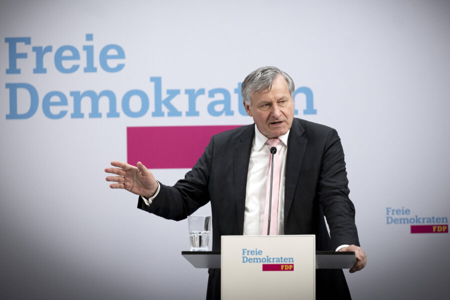 Ein Mann spricht an einem Rednerpult mit FDP-Logo, Hintergrund "Freie Demokraten".