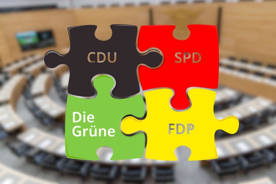 Vier Puzzleteile mit CDU, SPD, Die Grüne, FDP vor unscharfem Hintergrund.