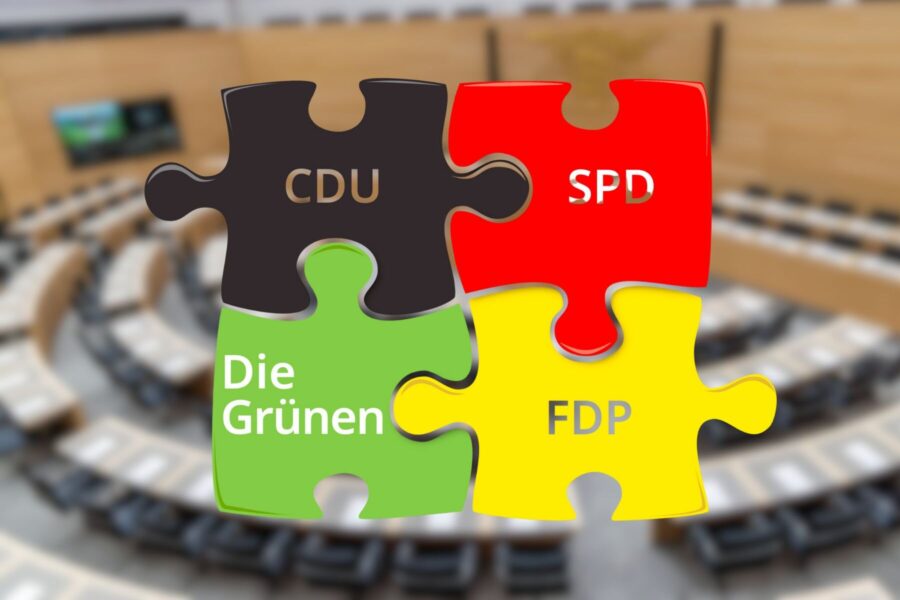 Vier Puzzleteile mit CDU, SPD, Die Grünen, FDP vor unscharfem Saal.
