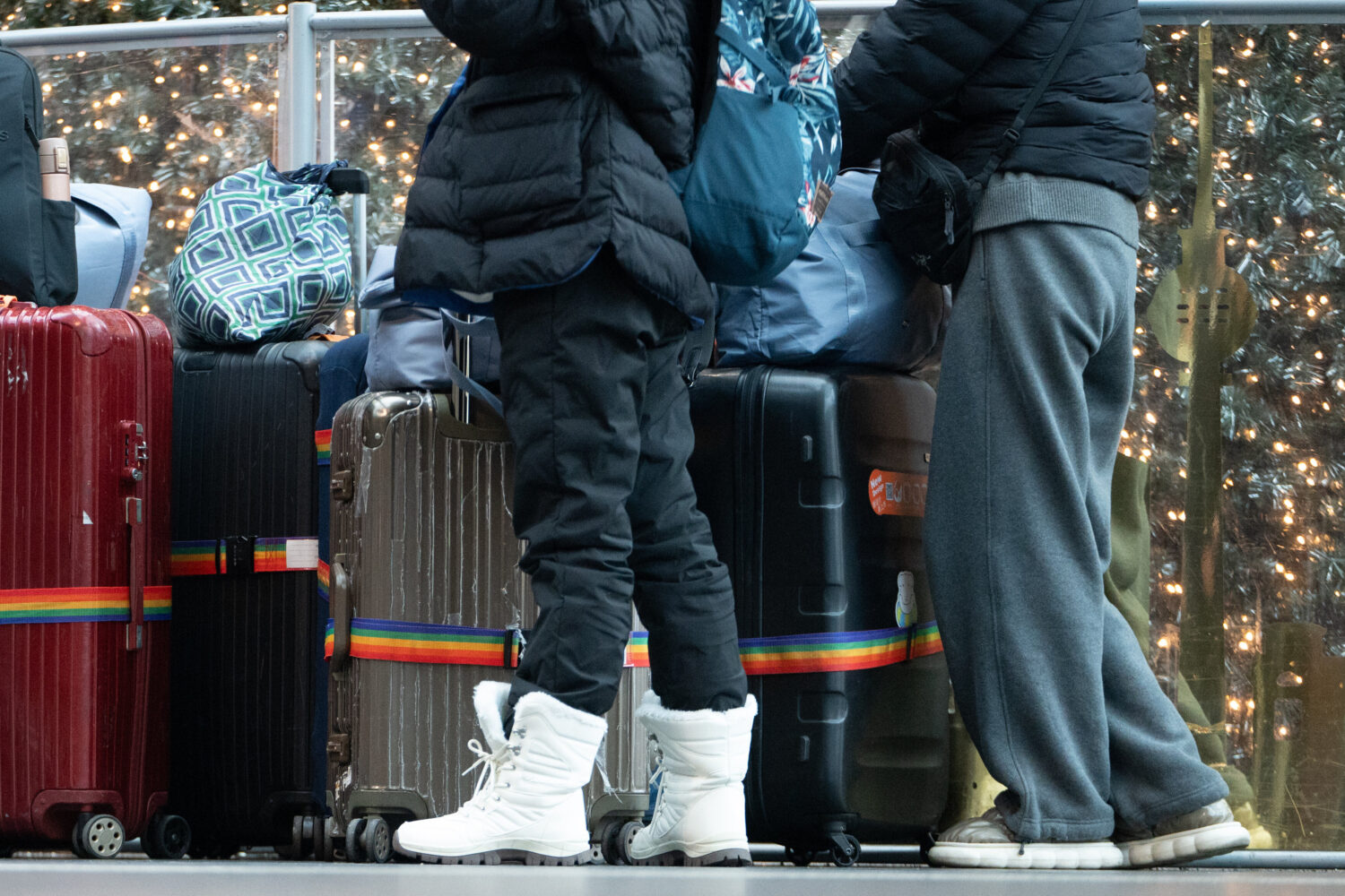 Zwei Personen mit Winterkleidung stehen bei mehreren Koffern und Taschen.