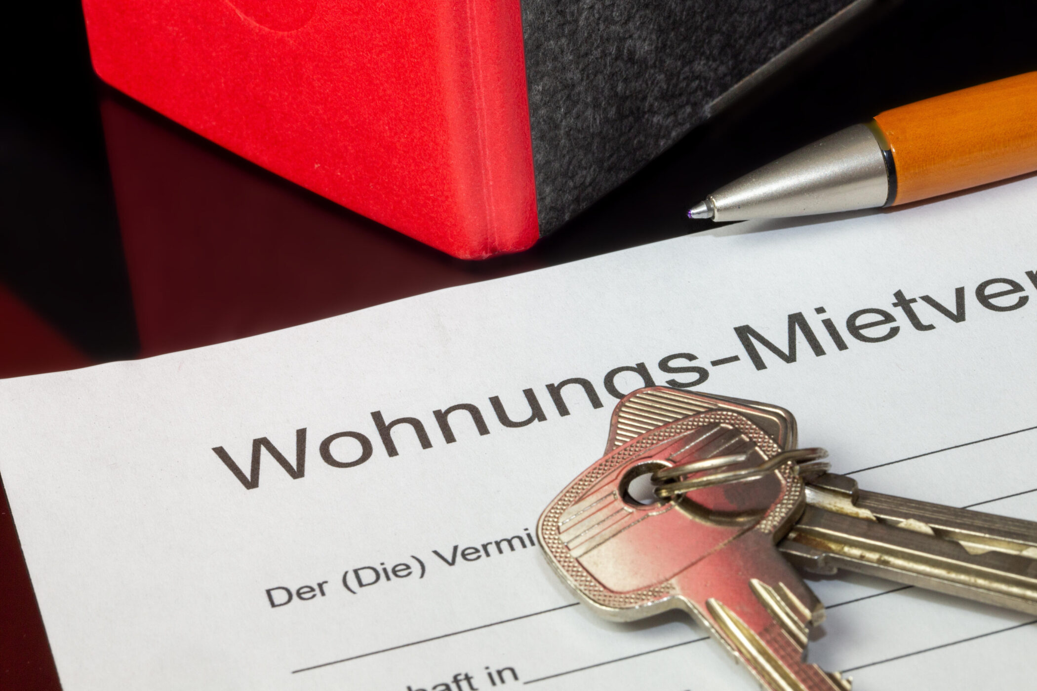 Schlüssel und Stift auf einem Wohnungs-Mietvertrag.