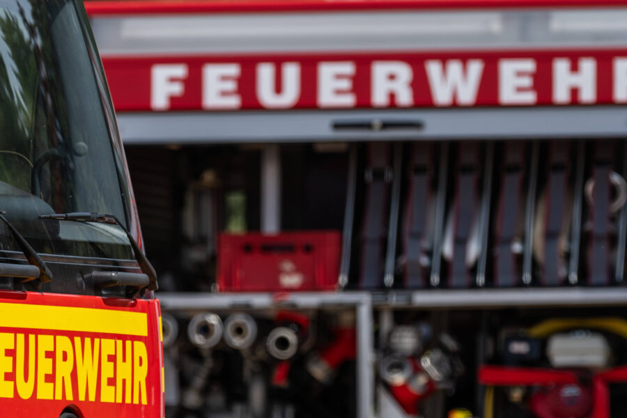 Feuerwehrfahrzeug mit Ausrüstung, Schriftzug "FEUERWEHR" auf rotem Hintergrund.