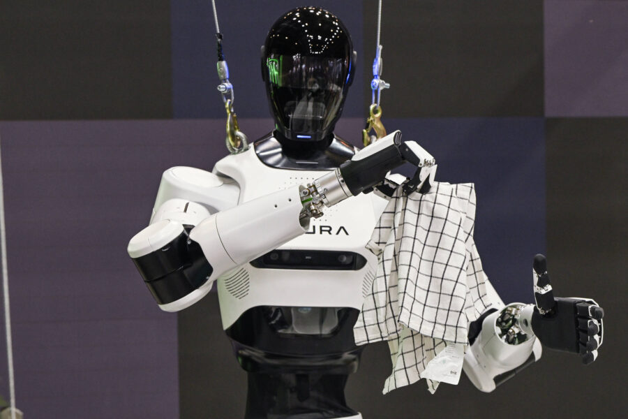 Roboter mit schwarzem Kopf hält kariertes Tuch, an Seilen befestigt.