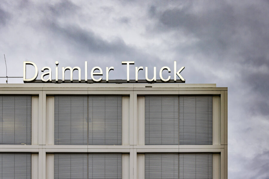 Gebäude mit Schriftzug "Daimler Truck" vor bewölktem Himmel.