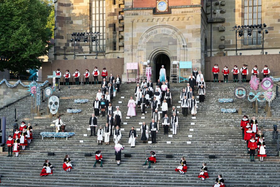 Viele Menschen in historischen Kostümen auf einer großen Treppe vor einem Gebäude.