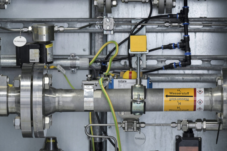 Rohrleitungssystem mit Aufschrift "H₂ Wasserstoff" und mehreren Ventilen und Anschlüssen.