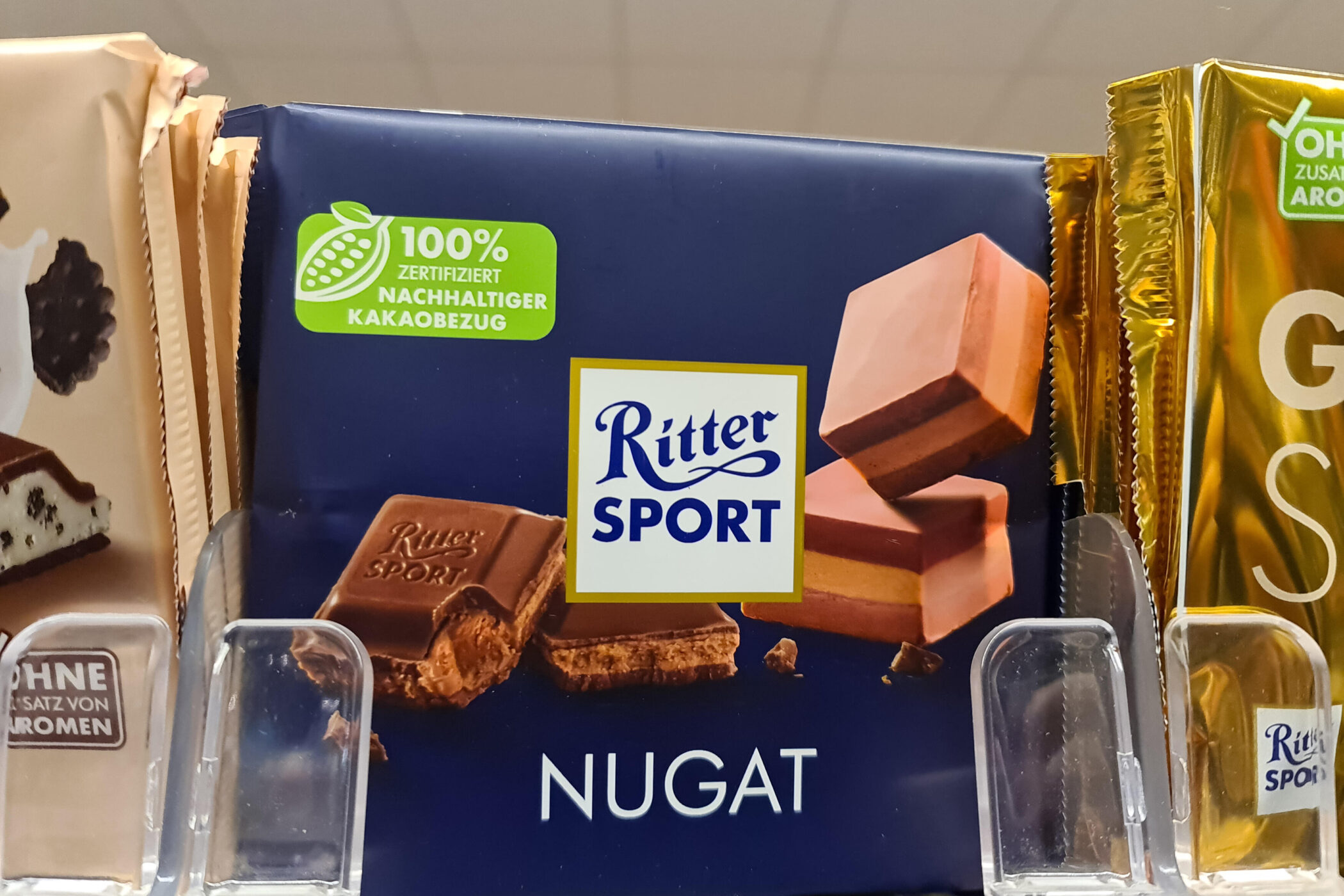 Ritter Sport Nugat Schokolade mit nachhaltigem Kakao, im Regal präsentiert.