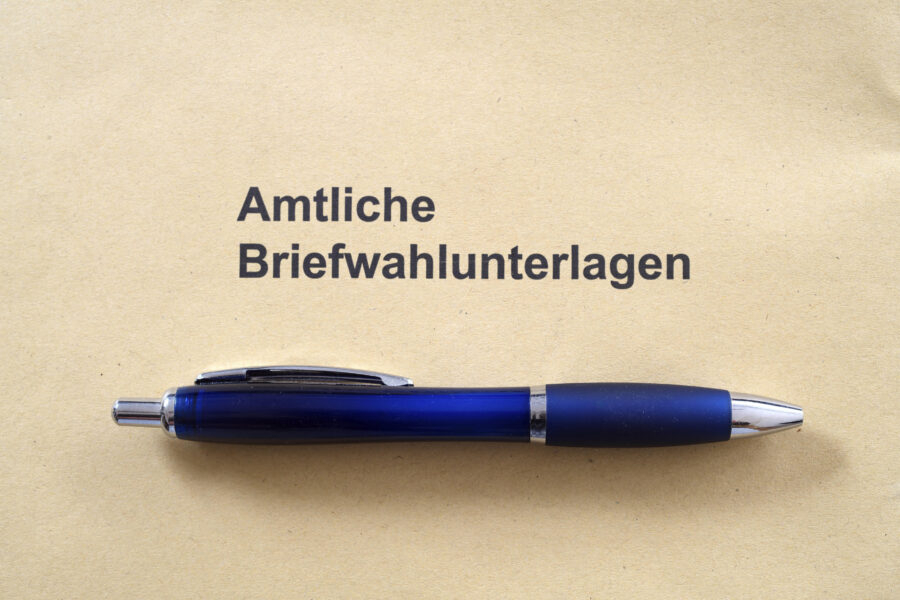 Umschlag mit Aufschrift "Amtliche Briefwahlunterlagen", blauer Kugelschreiber darauf.