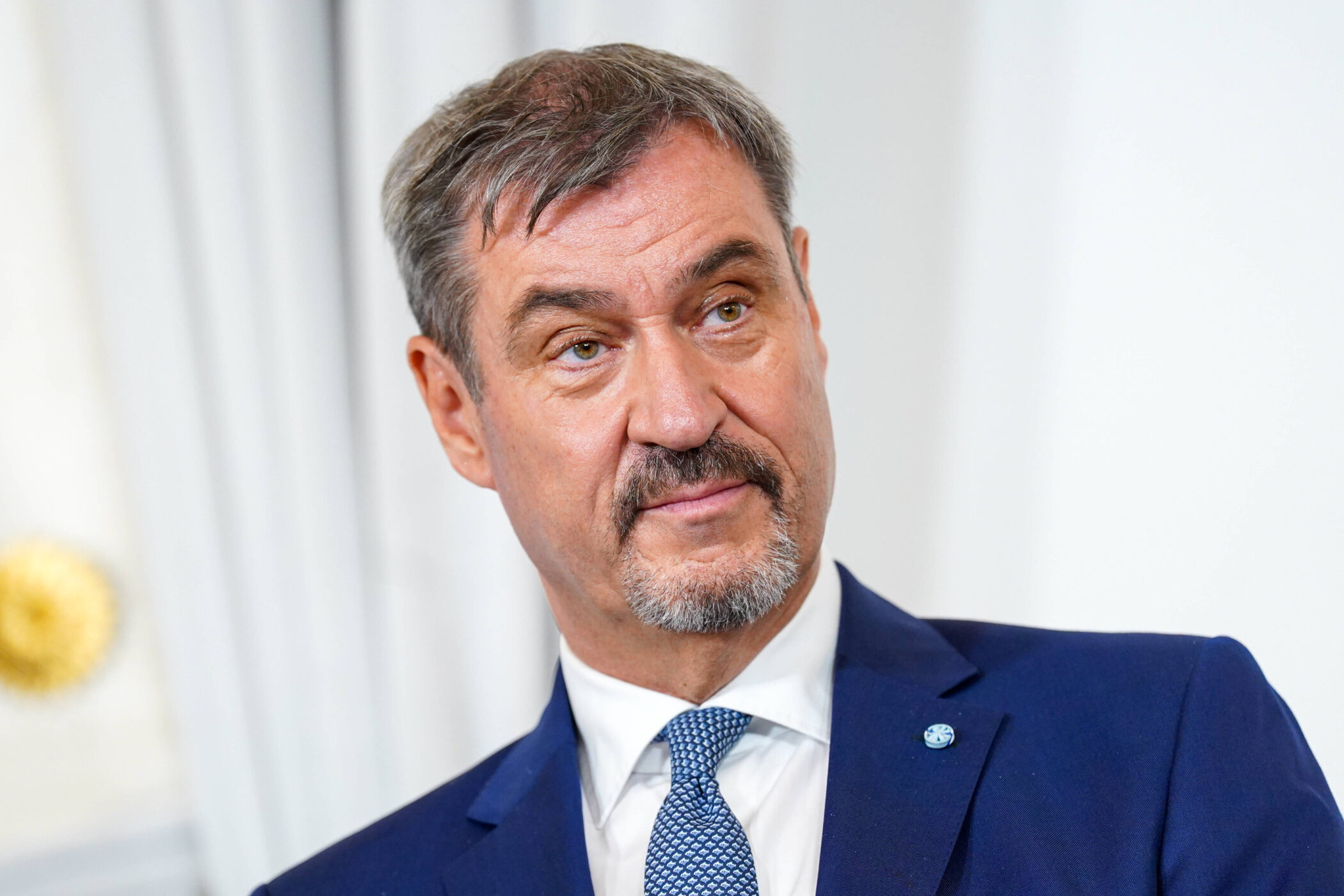 Ein Mann in Anzug und Krawatte blickt zur Seite.