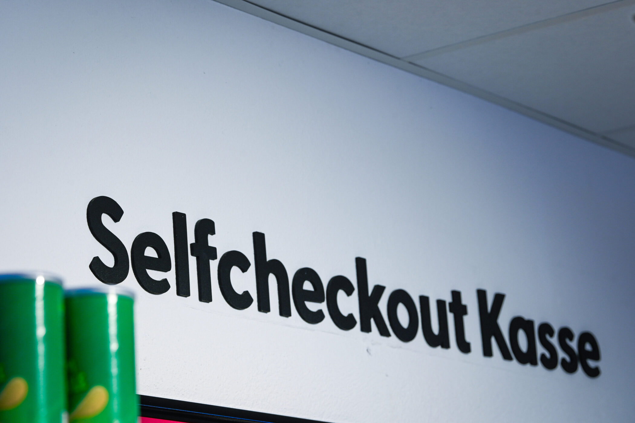 Schriftzug "Selfcheckout Kasse" an einer Wand.