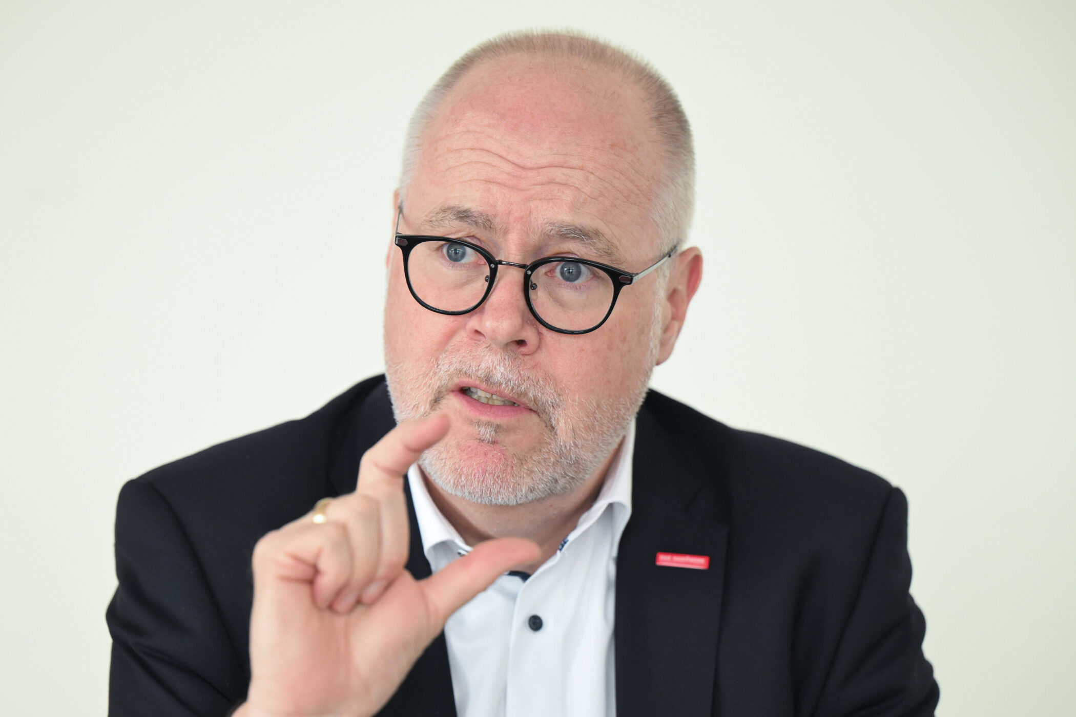 Mann mit Brille und Bart gestikuliert mit Hand.