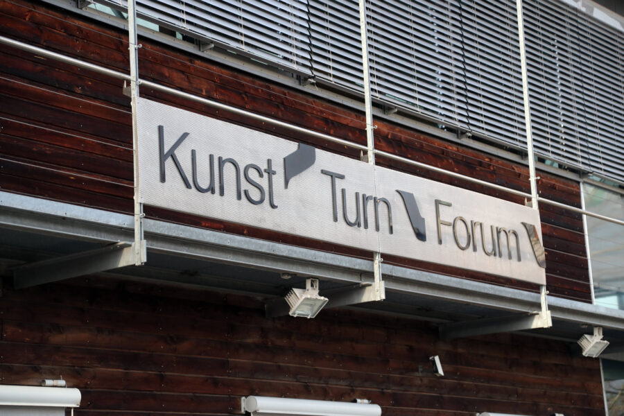 Schild mit der Aufschrift "Kunst Turn Forum" an einer Holzfassade.