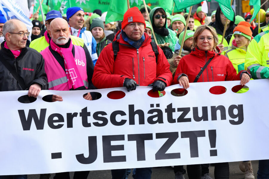 Mehrere Personen halten ein Banner mit der Aufschrift "Wertschätzung - JETZT!".