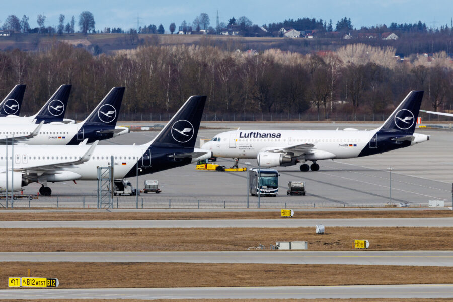 Mehrere Lufthansa-Flugzeuge parken auf einem Flughafen.