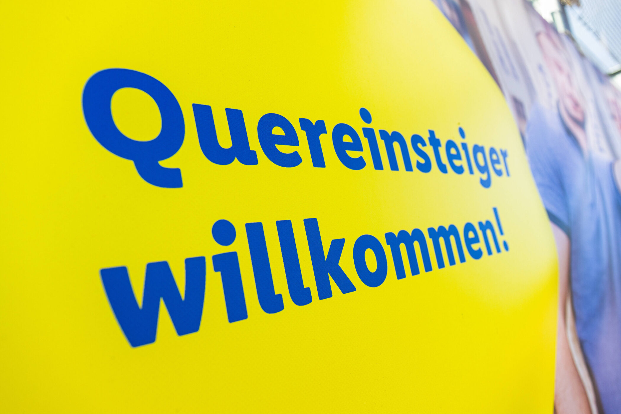 Gelbes Schild mit blauem Text: "Quereinsteiger willkommen!"