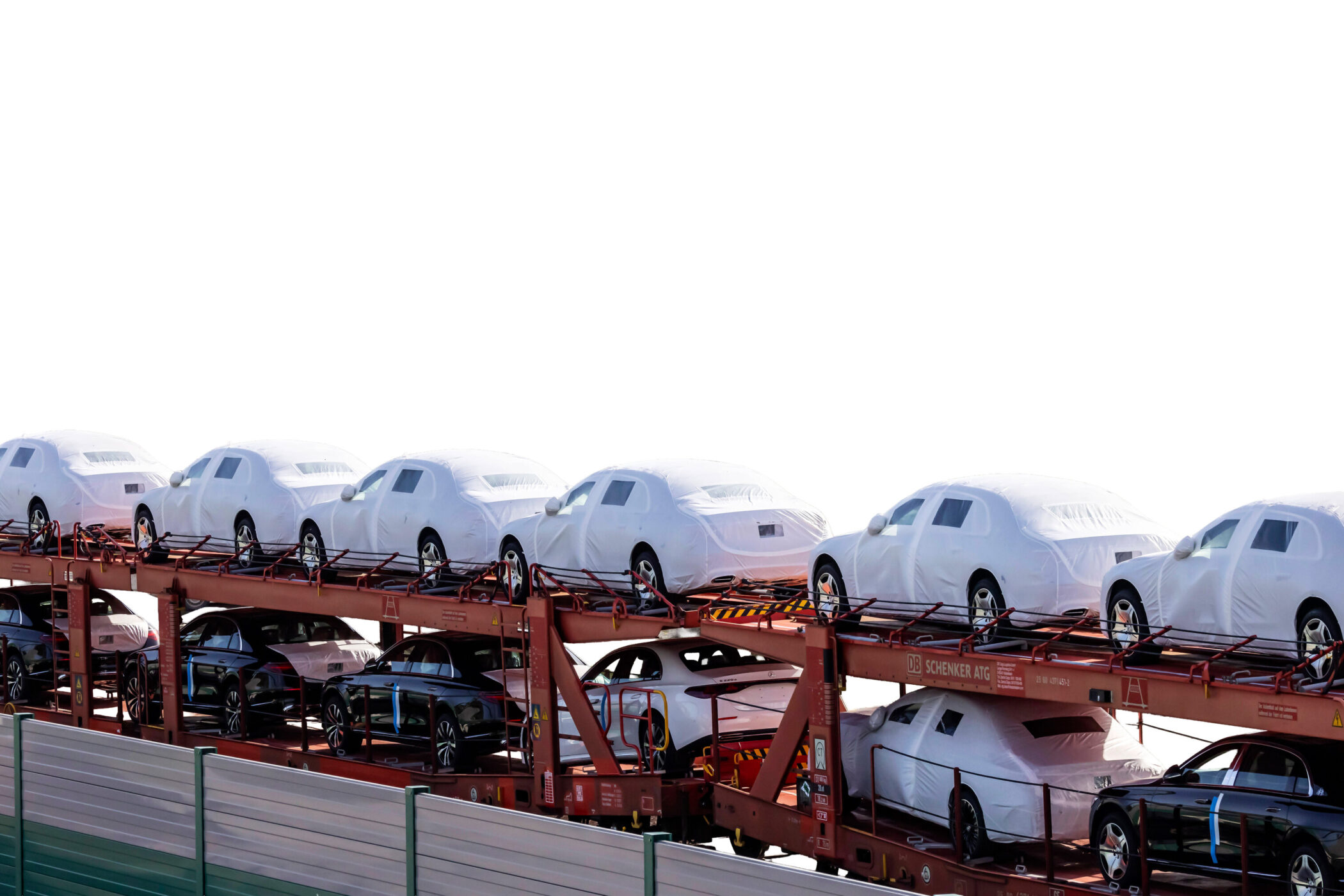 Auf einem Zug verladen, mit Planen abgedeckte und sichtbare Autos in zwei Reihen.