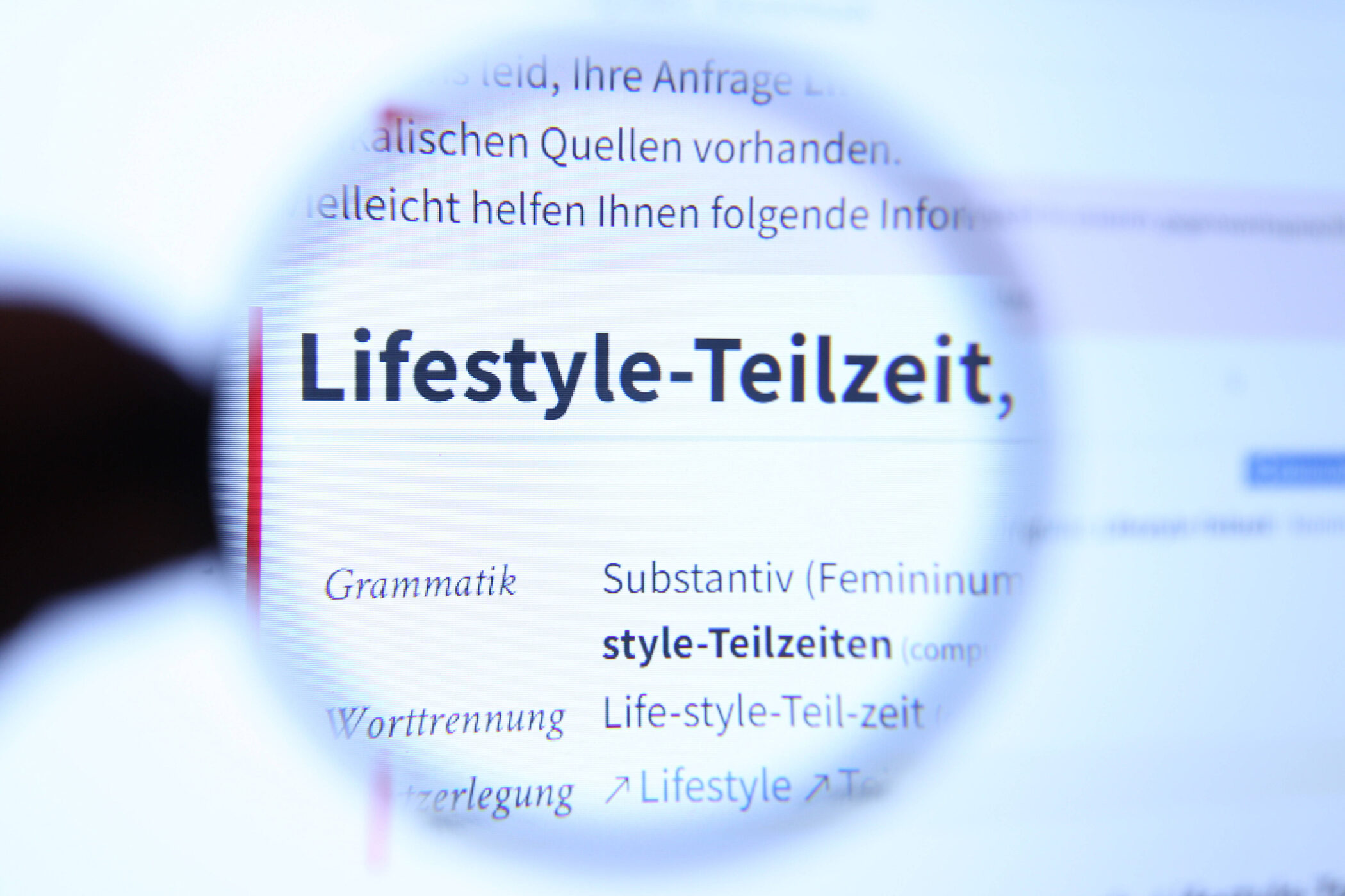 Lupe vergrößert Text "Lifestyle-Teilzeit" auf einem Bildschirm.