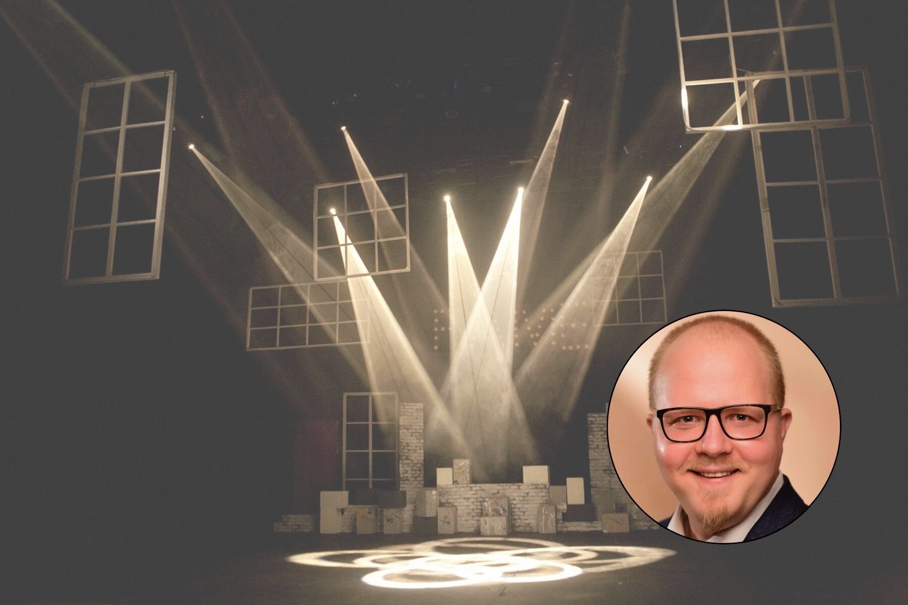 Bühne mit Scheinwerfern und schwebenden Rahmen, Porträt eines Mannes unten rechts.