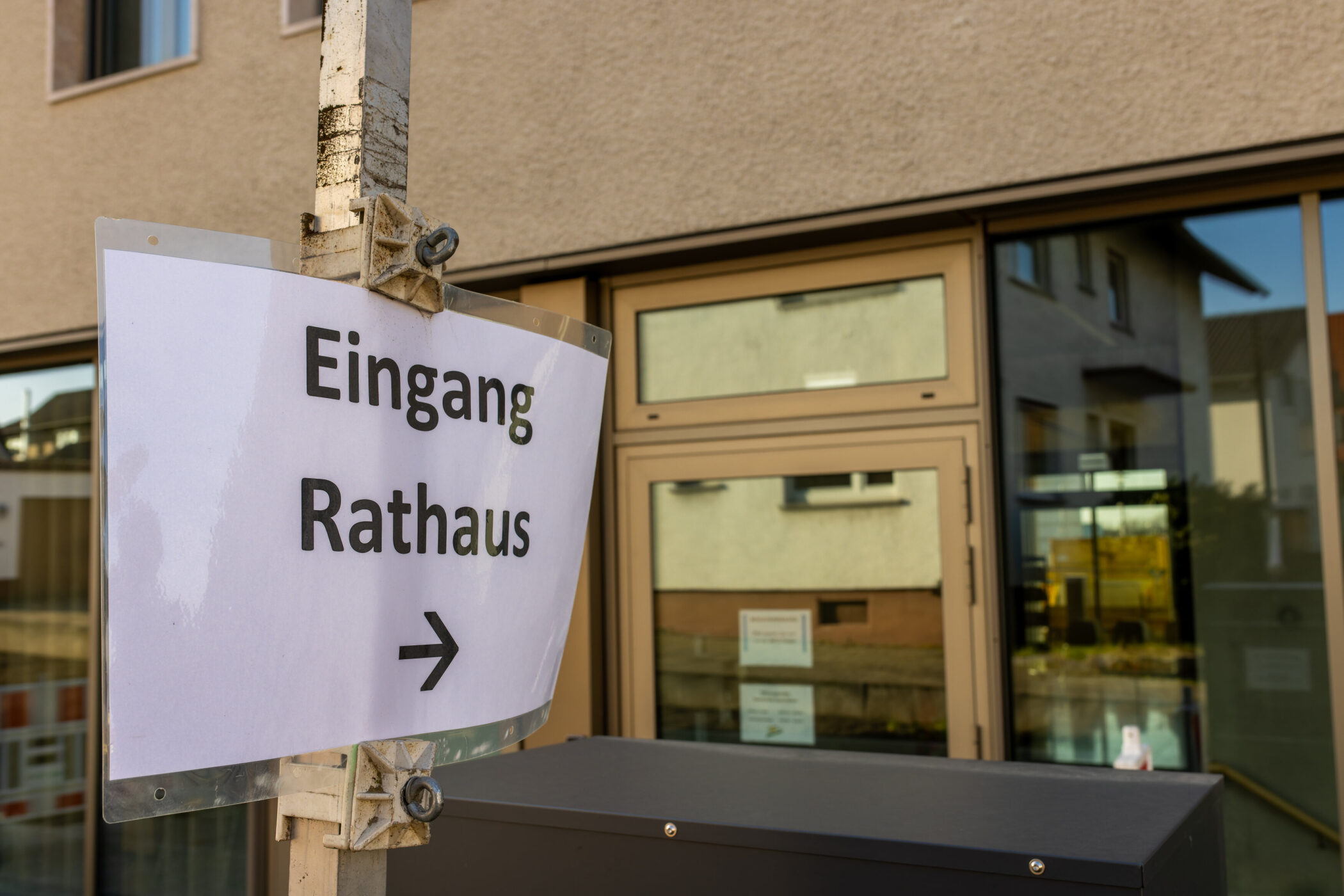 Schild mit Aufschrift "Eingang Rathaus" und Pfeil nach rechts.