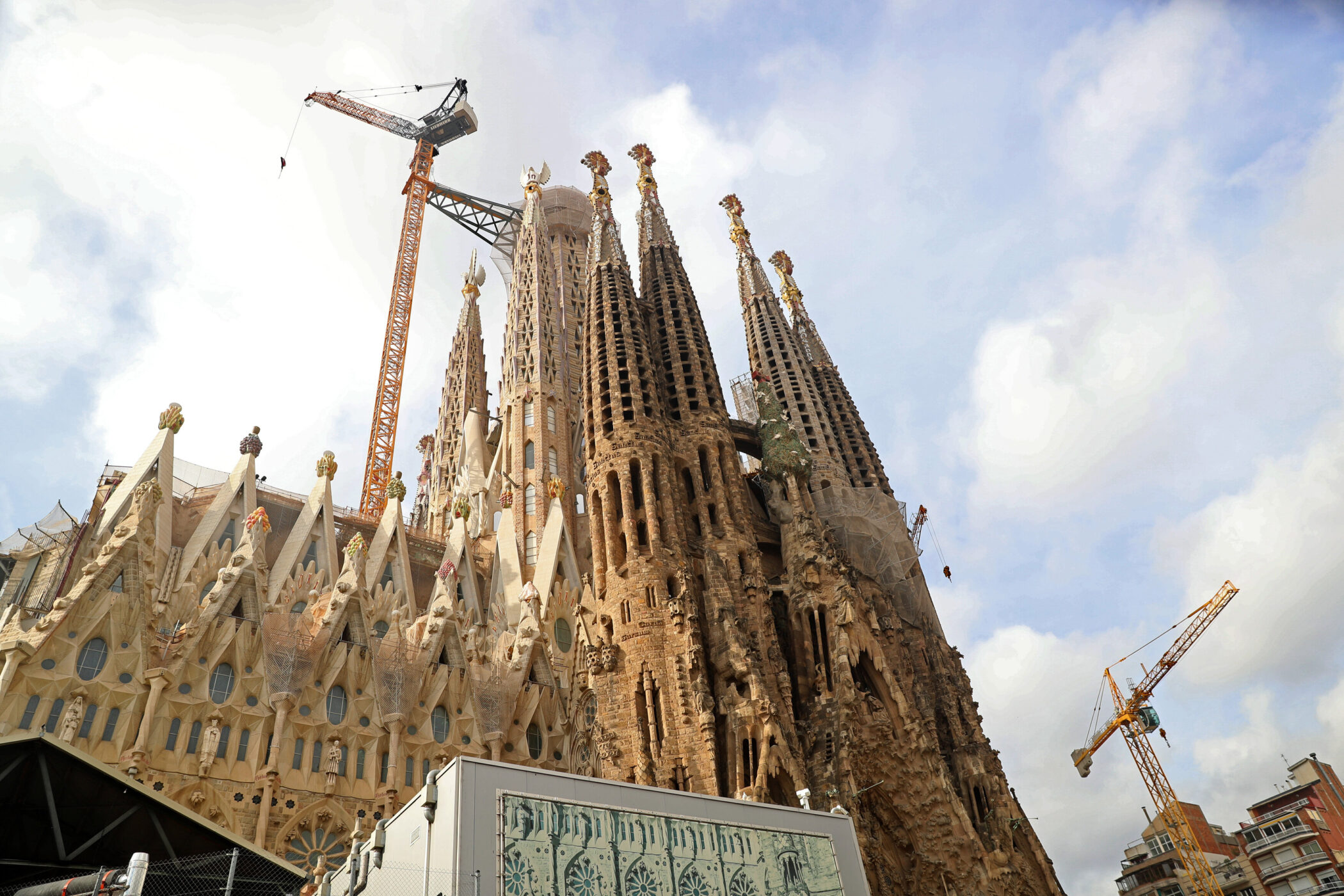 Kirchtürme der Sagrada Família, Baukräne und blauer Himmel.