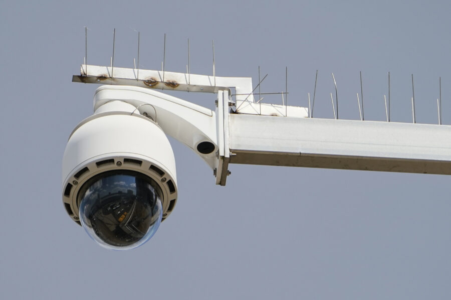 Überwachungskamera an einem Metallarm mit Spikes gegen Vögel.