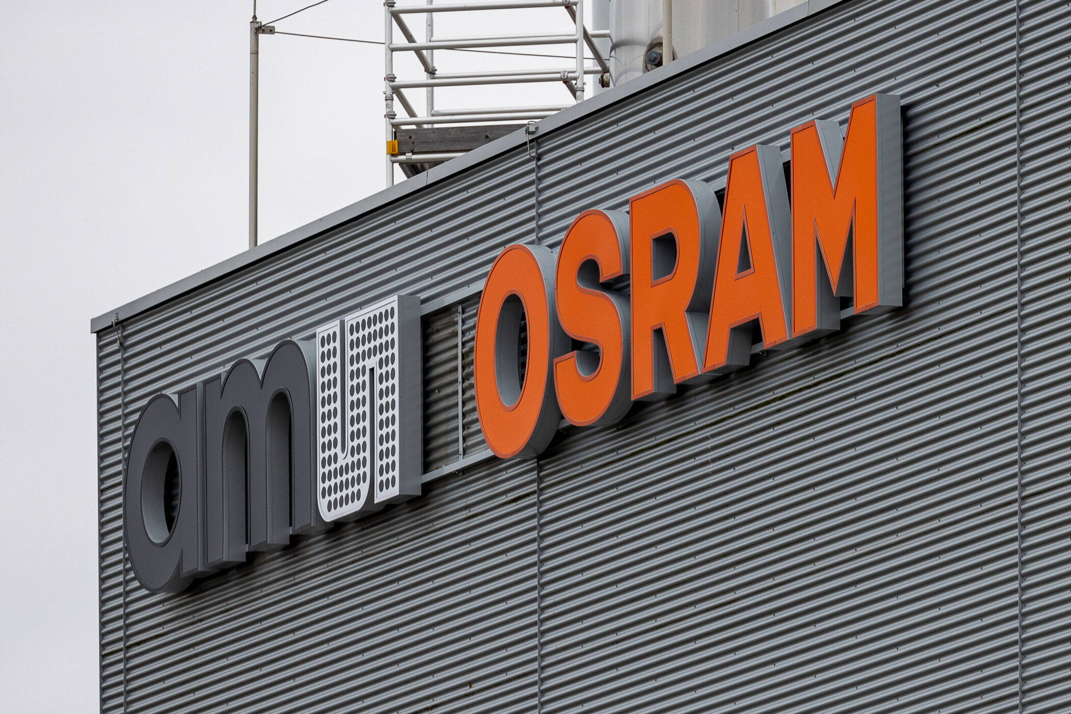 Gebäudewand mit ams OSRAM-Logo in großen Buchstaben.