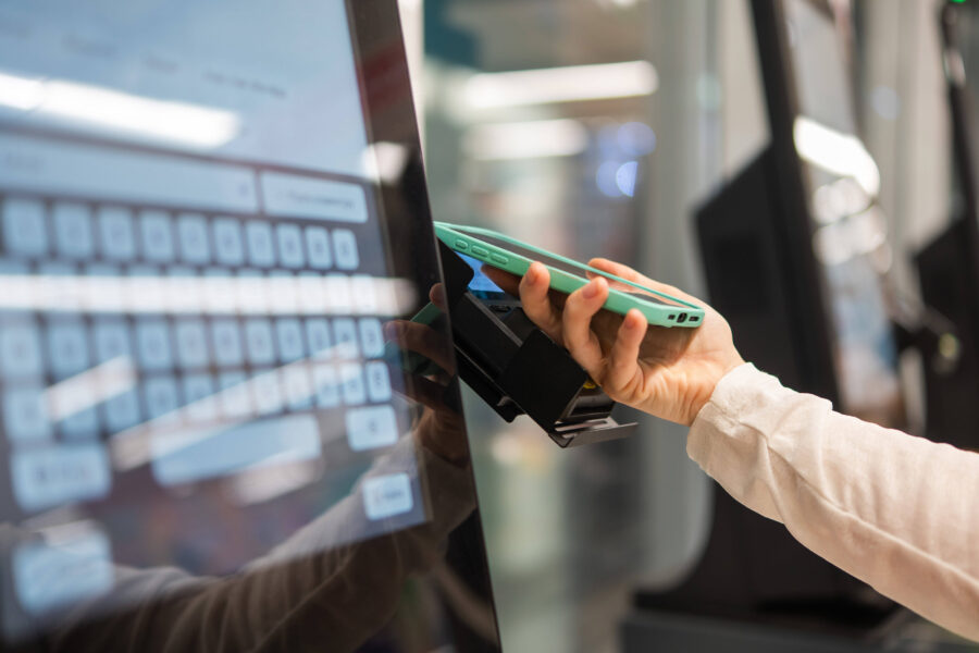 Hand hält Smartphone vor Bildschirm mit virtueller Tastatur.