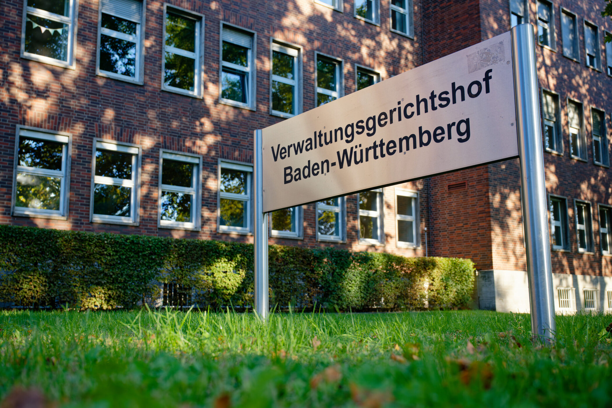 Schild mit Aufschrift "Verwaltungsgerichtshof Baden-Württemberg" vor Backsteingebäude.