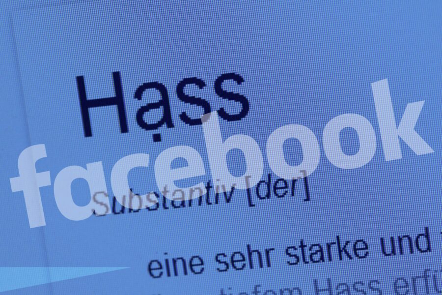 Wörter "Hass" und "facebook" blass auf einem Bildschirmhintergrund.