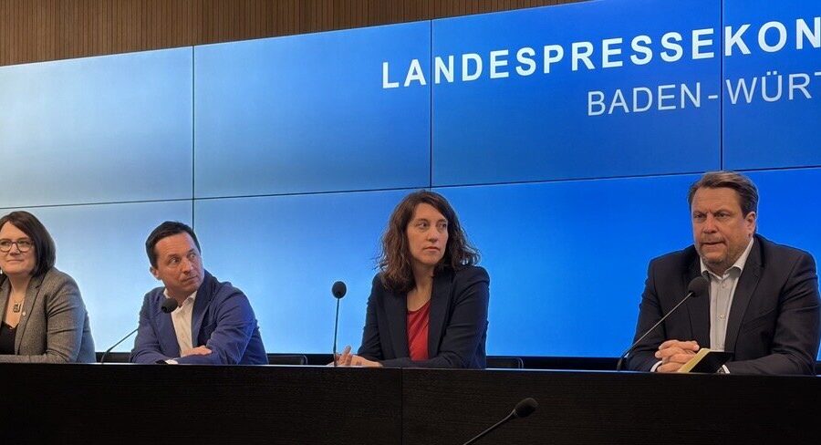 Vier Personen sitzen bei einer Pressekonferenz in Baden-Württemberg.
