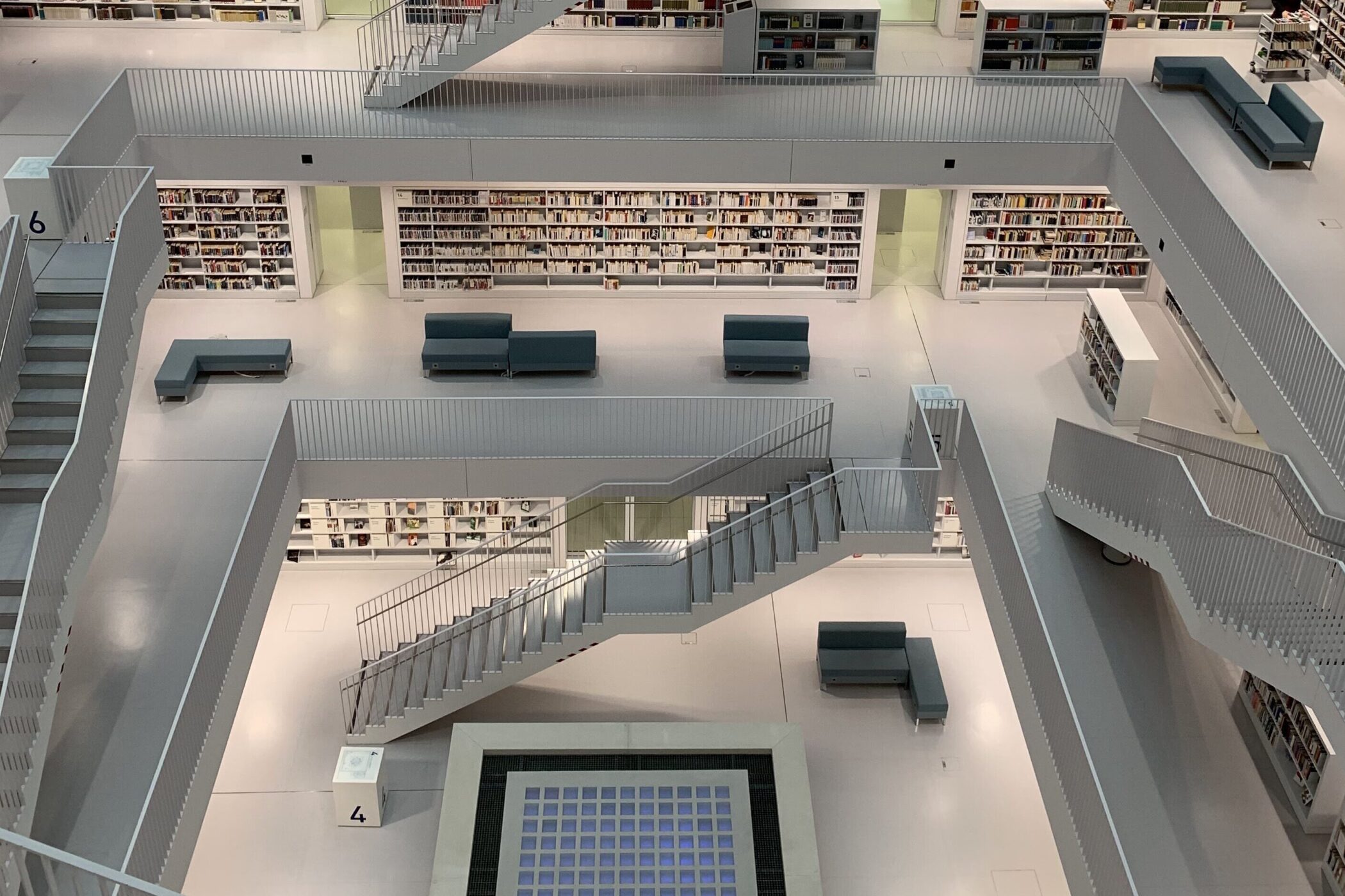 Moderne Bibliothek mit Treppen, Regalen und Sitzbereichen auf mehreren Ebenen.