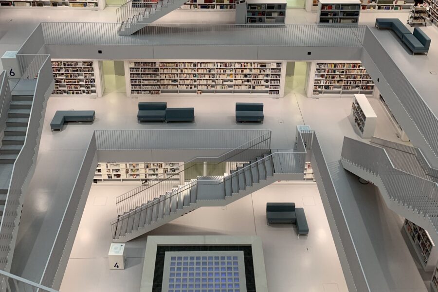 Moderne Bibliothek mit Treppen, Regalen und Sitzbereichen auf mehreren Ebenen.