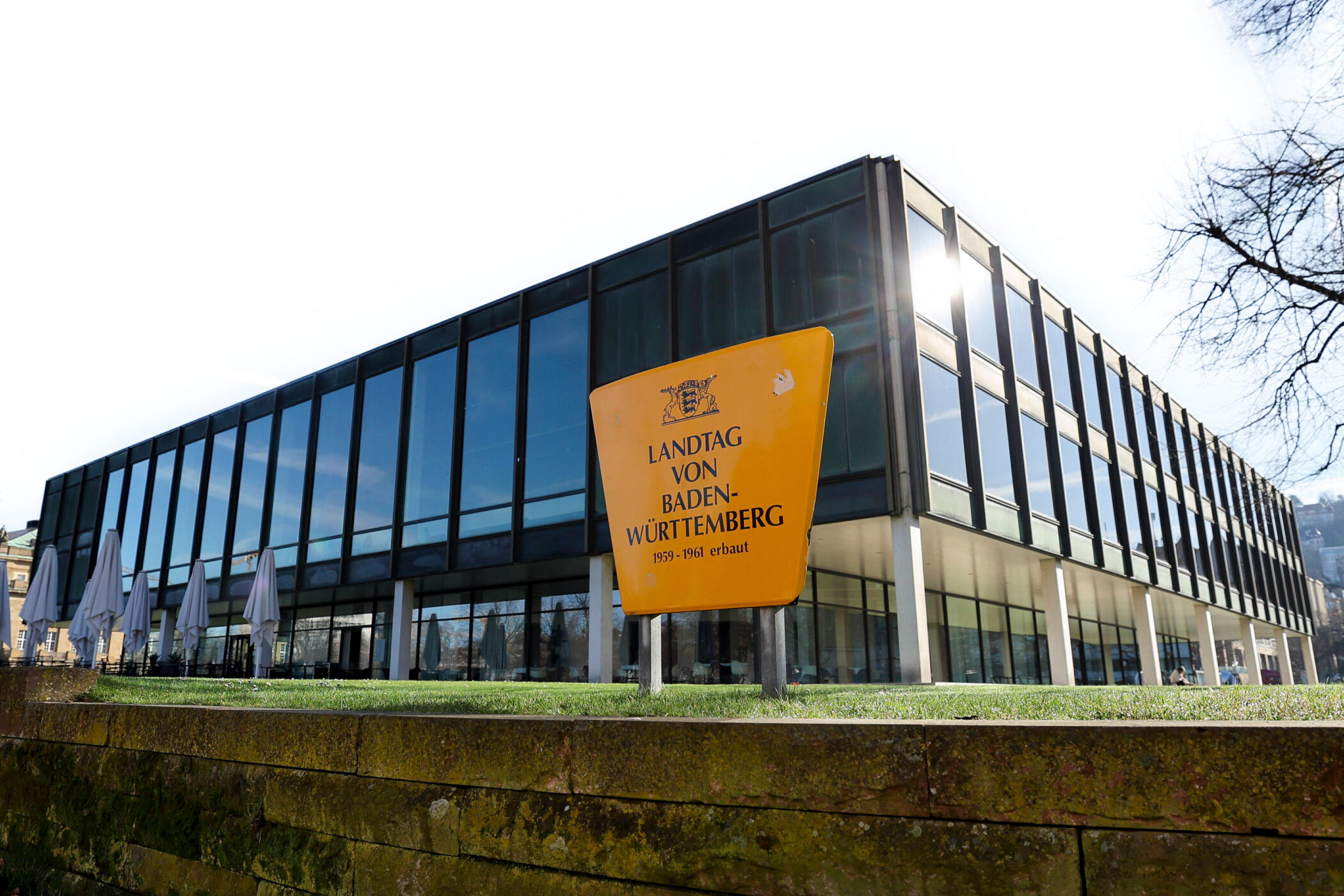 Glasgebäude mit gelbem Schild: "Landtag von Baden-Württemberg, 1959-1961 erbaut".