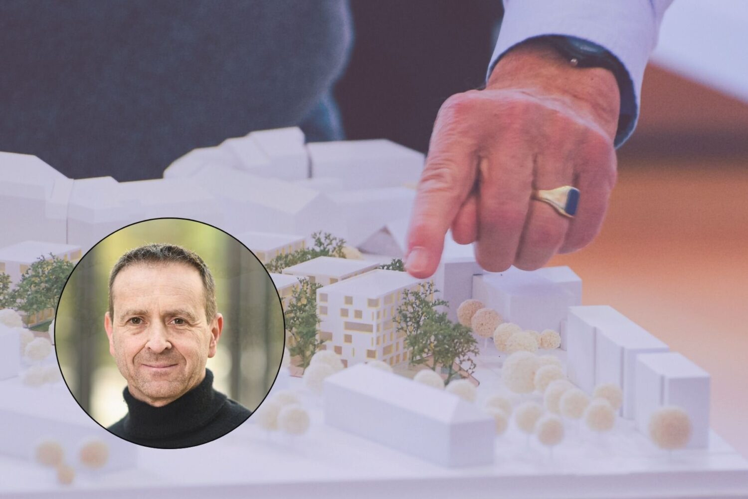 Hand zeigt auf Architekturmodell, Portrait eines Mannes mit schwarzem Rollkragen.