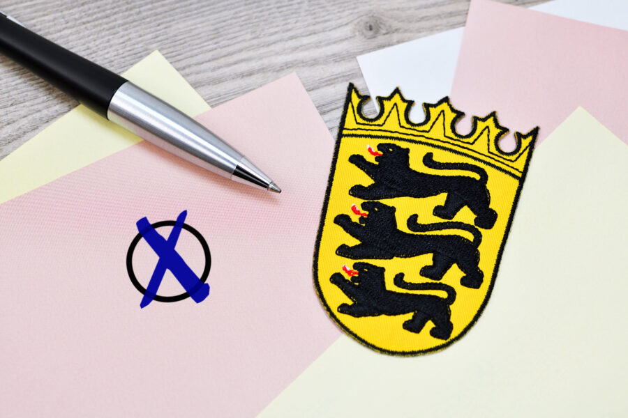 Kugelschreiber, Stimmzettel mit Kreuz, Wappen mit drei Löwen und Krone.