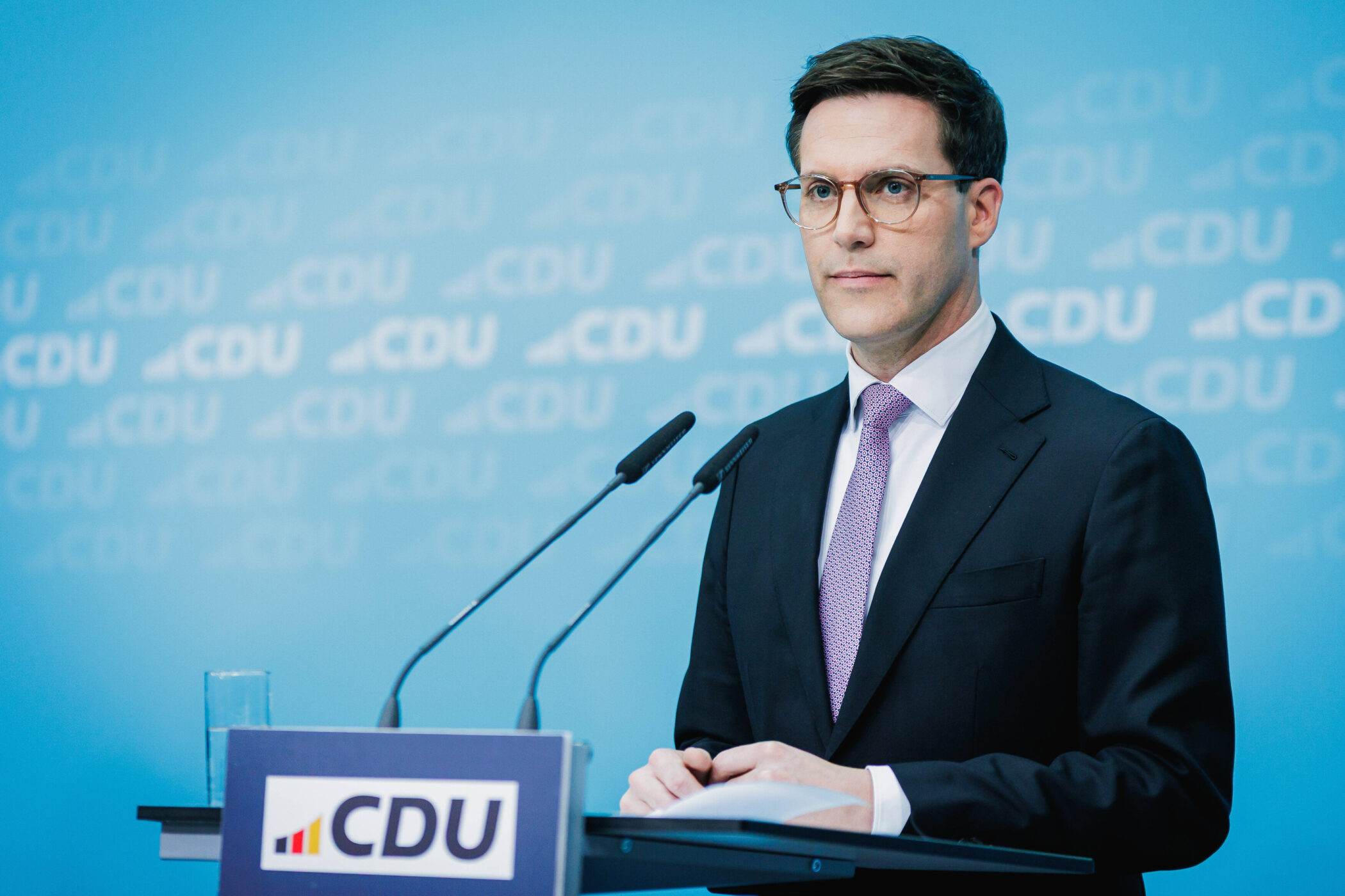 Ein Mann im Anzug steht an einem Rednerpult mit CDU-Logo.
