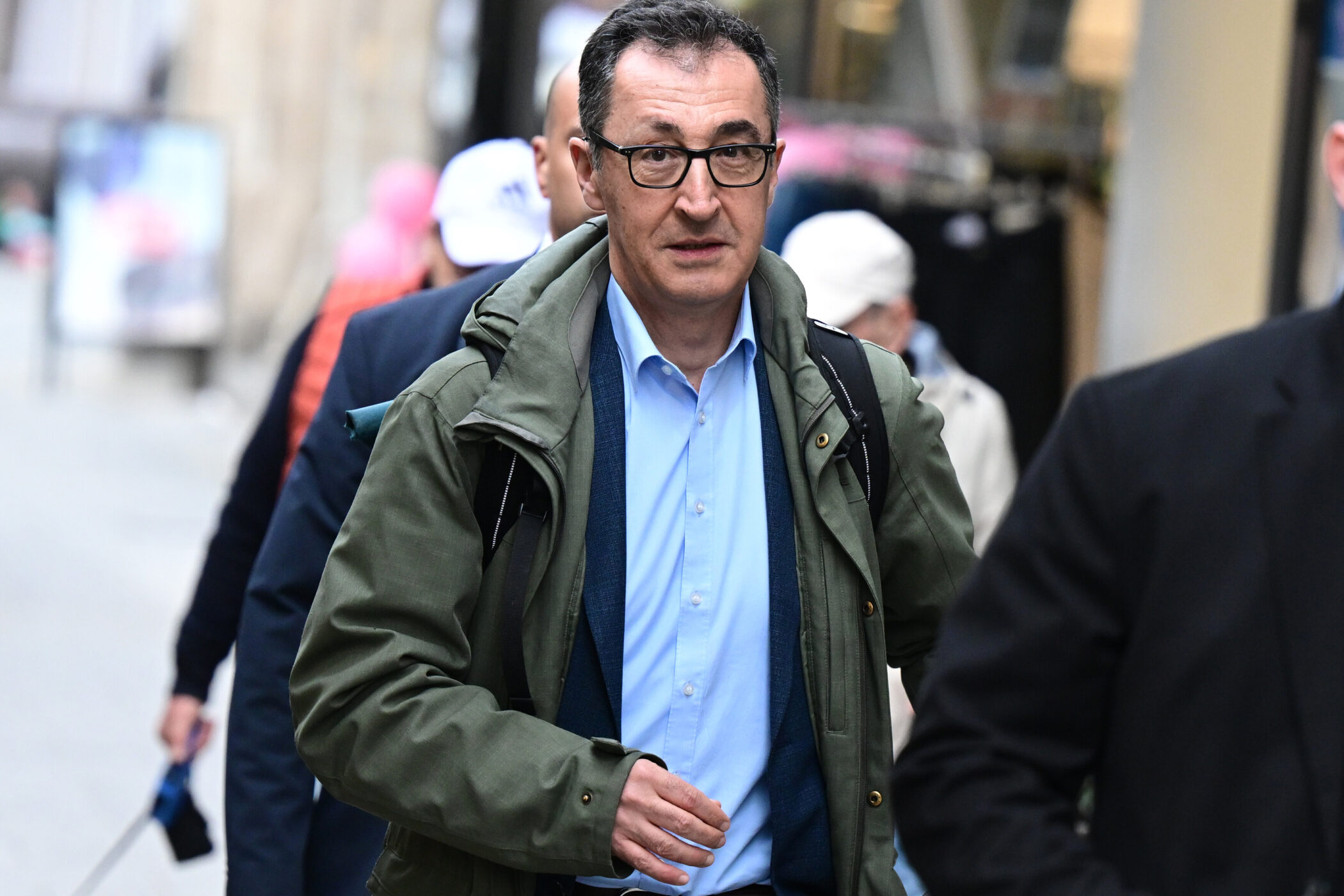 Mehrere Personen gehen auf einer belebten Straße.