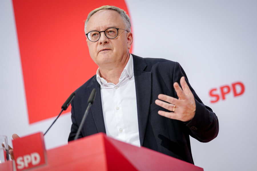 Mann mit Brille spricht am Rednerpult mit SPD-Logo, zwei Mikrofone vor ihm.