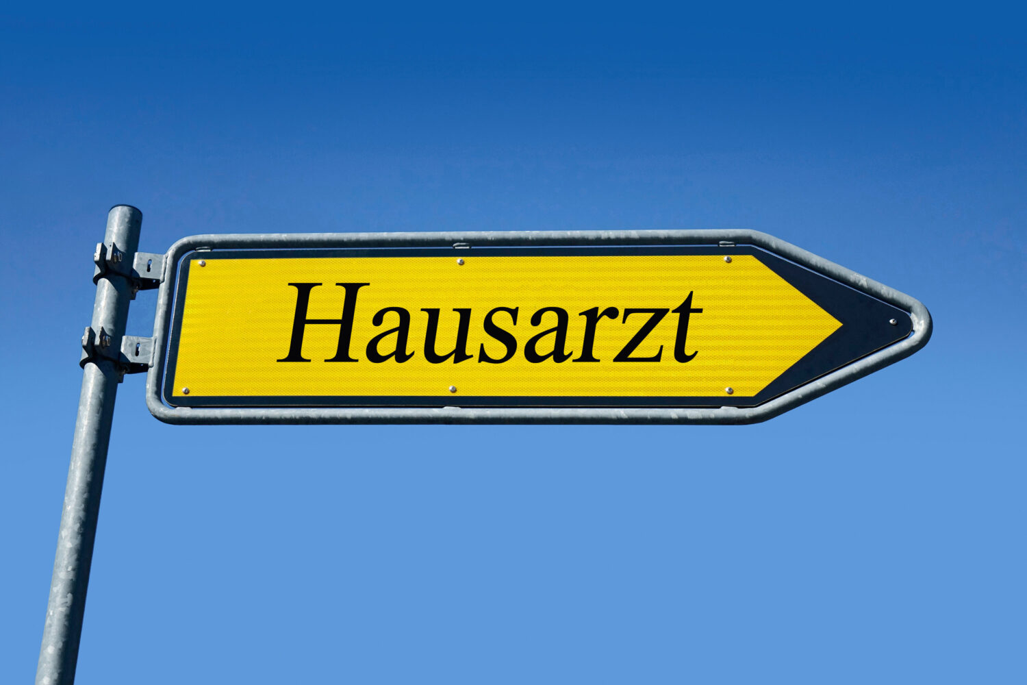 Gelbes Schild mit der Aufschrift "Hausarzt", blauer Himmel.