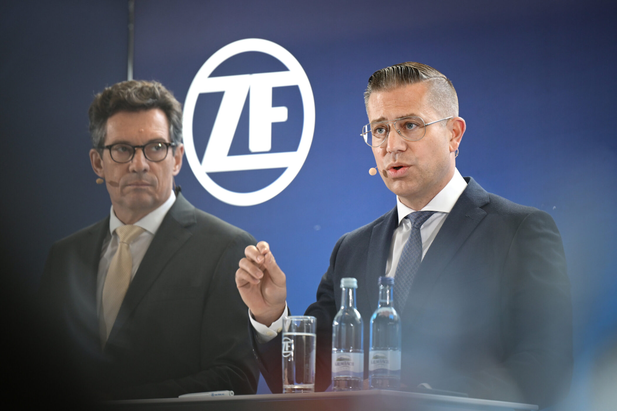 Zwei Männer in Anzügen am Rednerpult, ZF-Logo im Hintergrund.