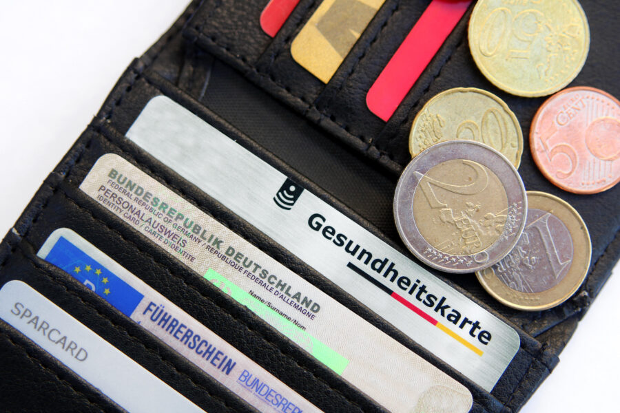 Portemonnaie mit Karten: Personalausweis, Führerschein, Gesundheitskarte. Münzen sichtbar.