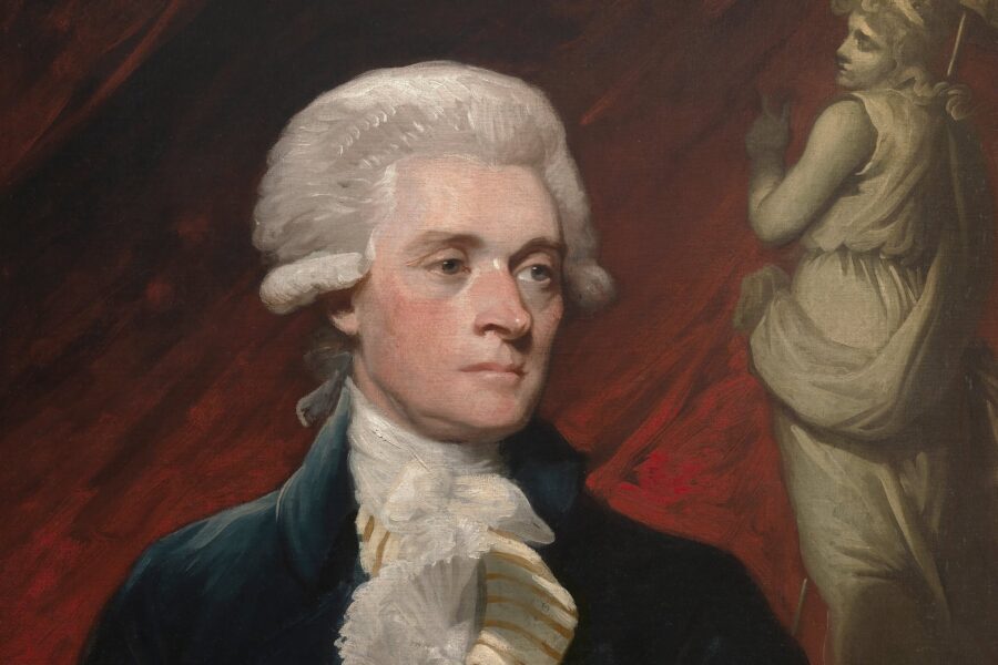 Person mit weißer Perücke in historischer Kleidung vor rotem Hintergrund.