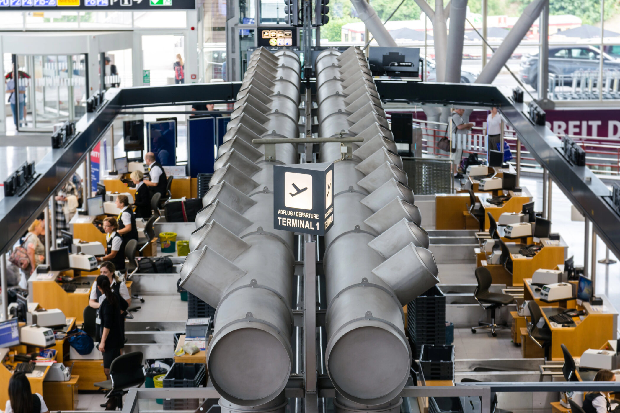 Blick auf Check-in-Schalter im Flughafen, Schild "Abflug Terminal 1".